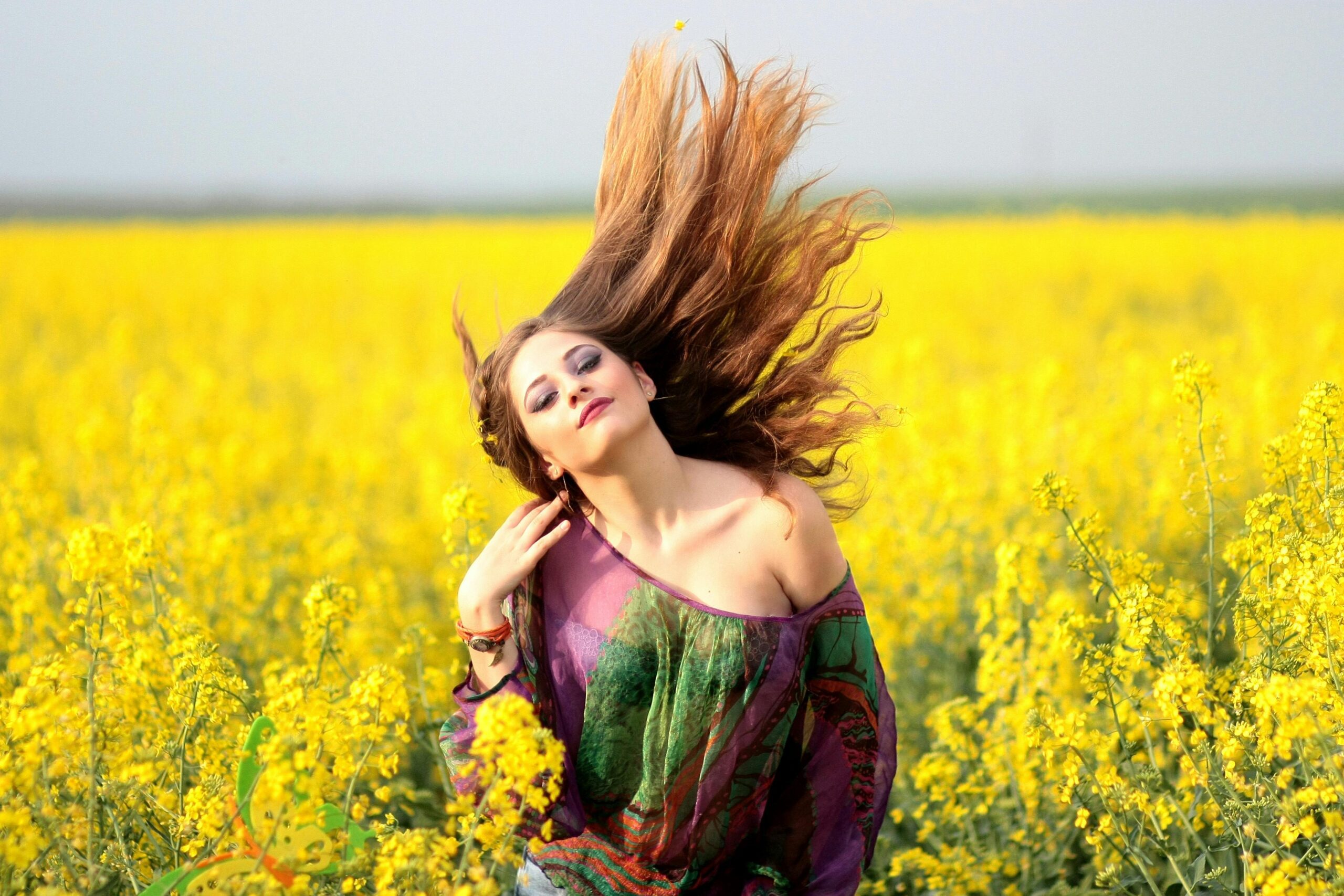 A girl standing in a sunflower field. Asking, 'What does it mean when someone says you smell like BO?