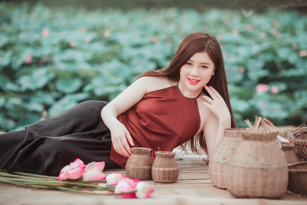 A beautiful girl lying alongside a canal, smiling happily.