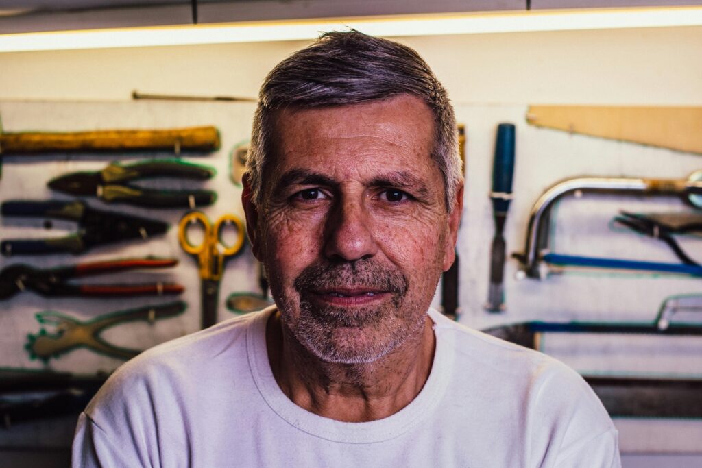 An aged man sitting confidently and looking forward.