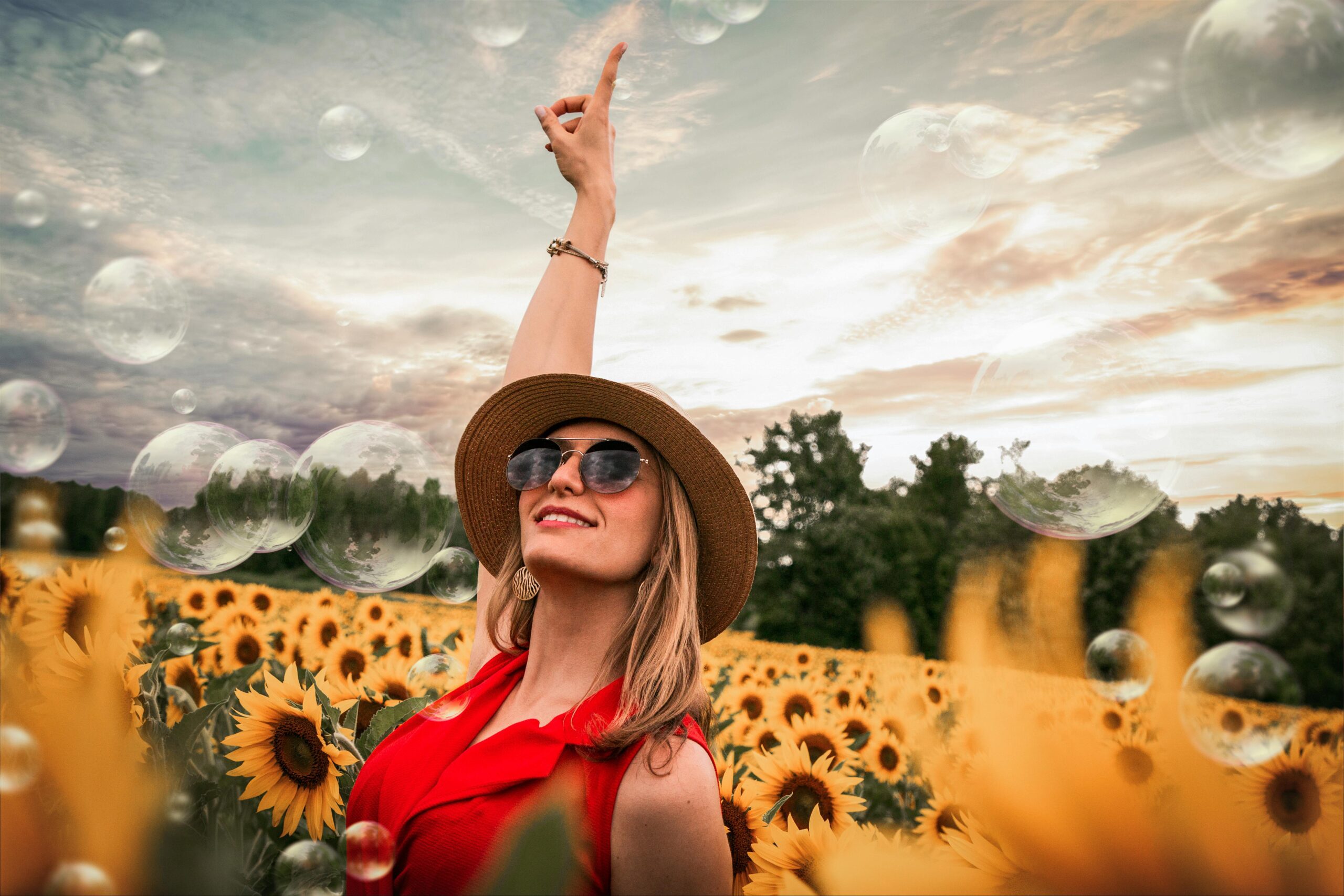 A beautiful girl standing in a sunflower field, wearing a cowboy hat. Wondering what it means when a girl wears a guy's hat.