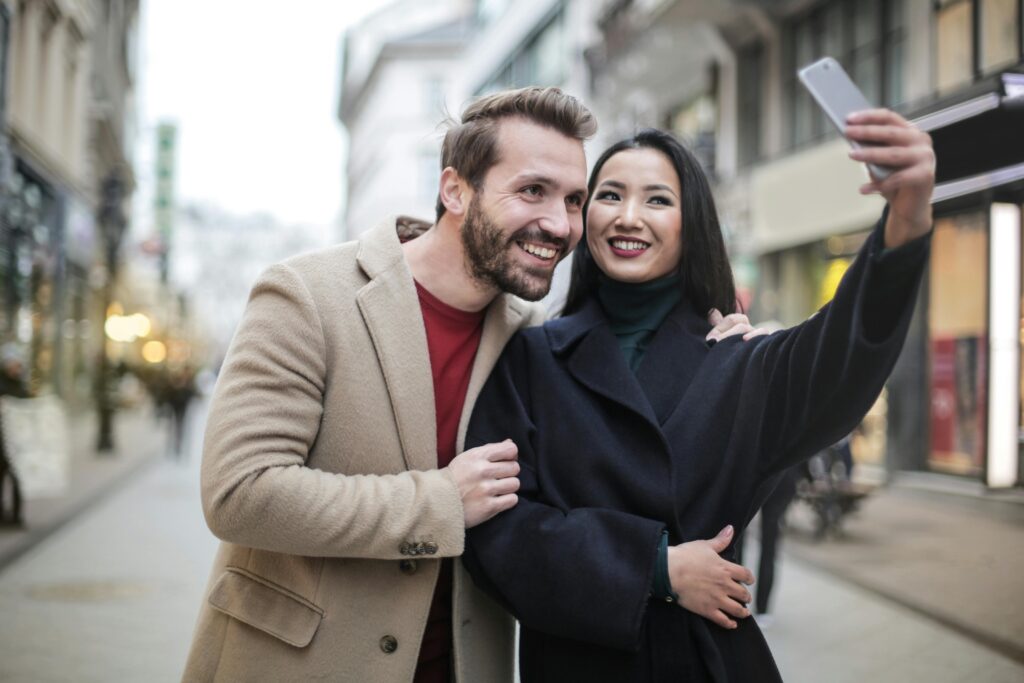 A man and a woman taking a selfie together on a road.