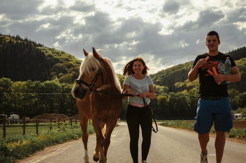 A couple riding through hills on their horse, enjoying the scenic views together.