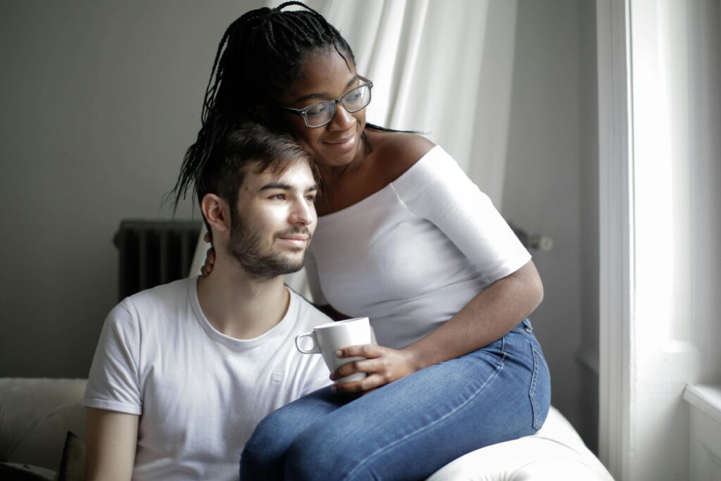 A couple sitting in a room, enjoying a quiet moment together over tea.