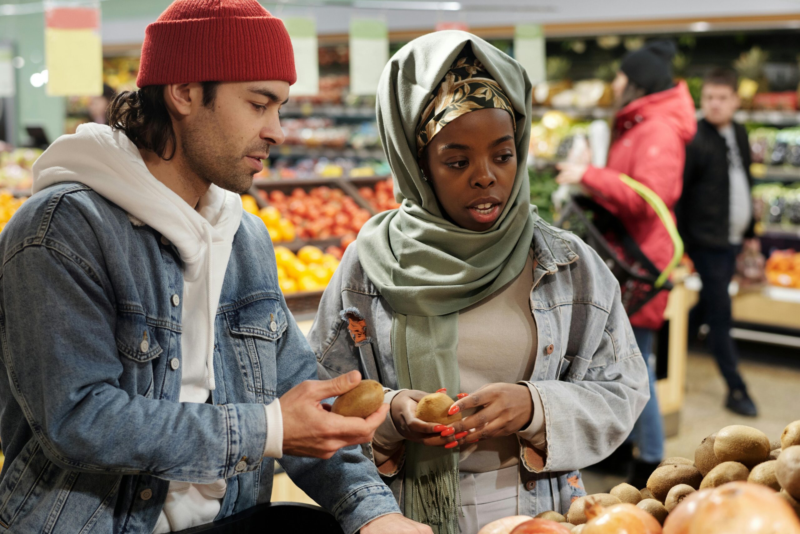 A couple happily shopping for vegetables together, while discussing what it means when a guy makes future plans with you.