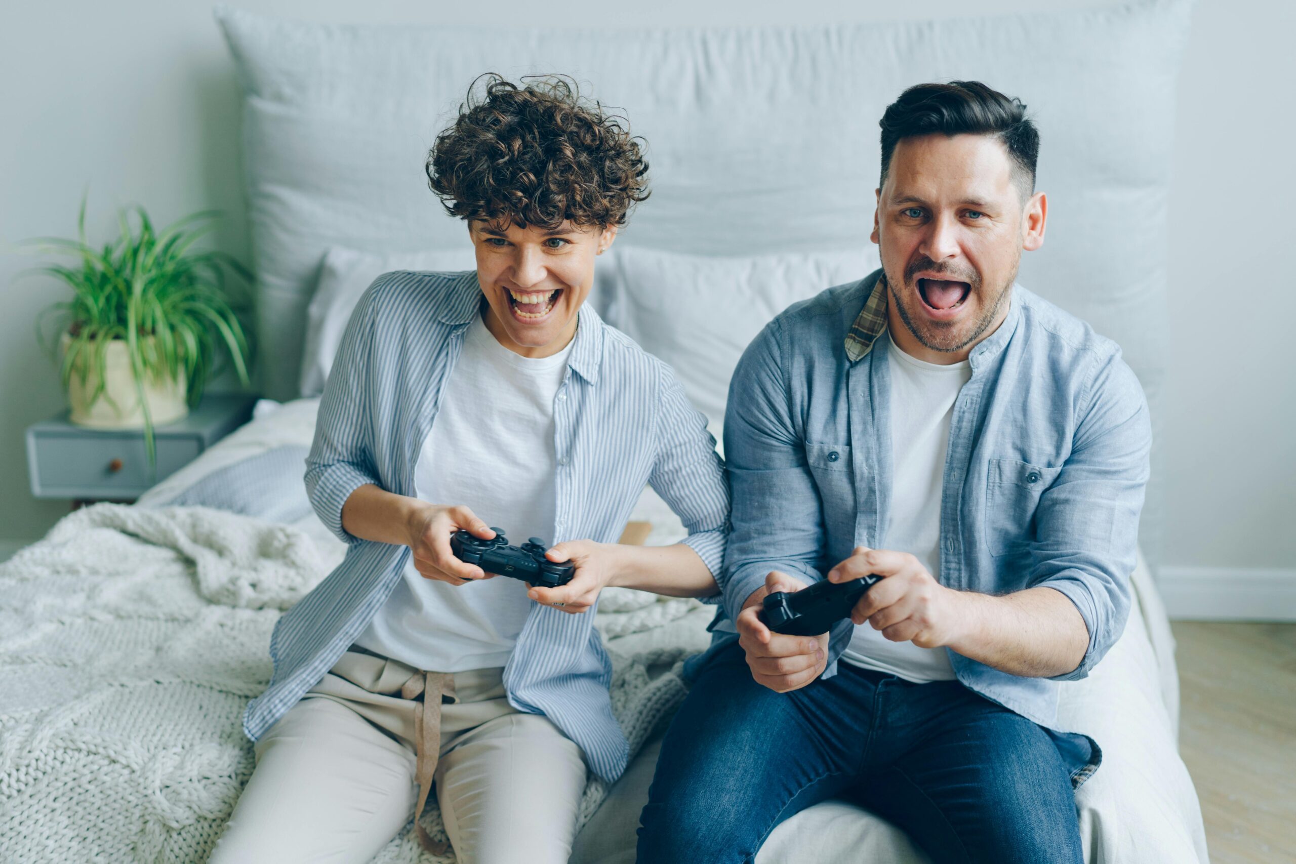 A couple sitting on their bed, playing games together. Wondering what it means when a guy playfully punches your arm.