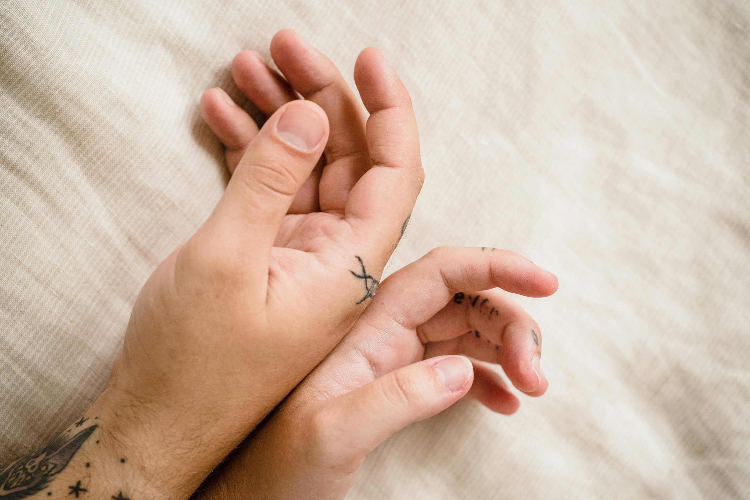 A man's hand gently touching a girl's hand, contemplating what it means when a guy playfully touches you.