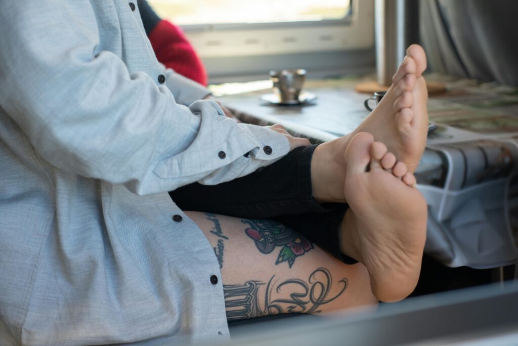 A boy rubbing the feet of his girlfriend affectionately.