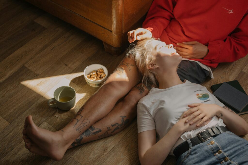 A couple lying on the floor and engaged in conversation.