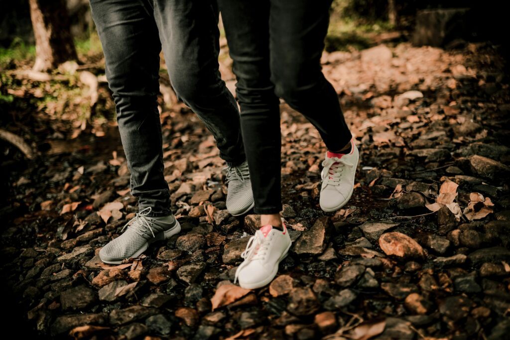 A couple walking through a forest and talking.
