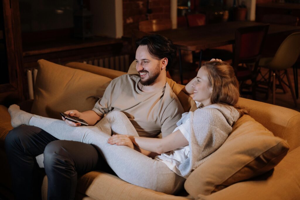 A couple sitting closely together on a sofa, sharing a moment of love and affection.